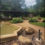A park with a pond and a pathway.