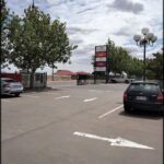 A parking lot with a sign that says "Parking" and a car that says "Parking" on the back.