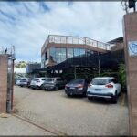 A parking lot with a variety of cars parked in front of a building.