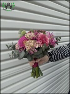 A person is holding a bouquet of flowers in their hand.