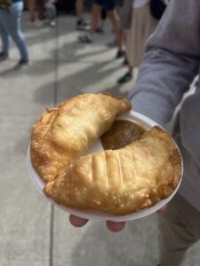 A person is holding a plate with two pastries on it.