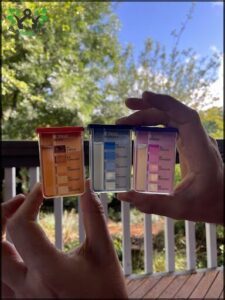 A person is holding up a box of different colored pills, showing the variety of medications available.