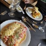 A person is sitting at a table with a plate of food in front of them.