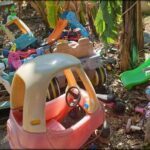 A pink toy car is parked in front of a bunch of other toy cars.