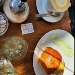 A plate of food sits on a table, accompanied by a cup of coffee and a glass of water.