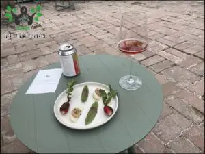 A plate of food sits on a table next to a wine glass.