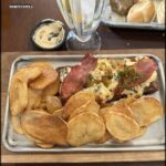 A plate of food with a sandwich, fries, and a drink.
