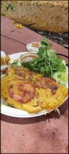 A plate of food with a variety of items, including a sandwich, salad, and vegetables.