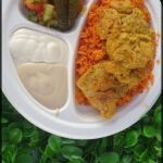 A plate of food with rice, meat, and vegetables.