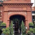 A red brick archway with a green plant in the middle.