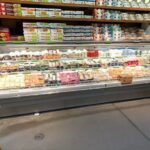 A refrigerated display case filled with various food items.