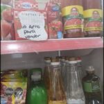 A refrigerator filled with various food items, including a bottle of olive oil and a bottle of tomato sauce.