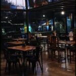 A restaurant with a large window and a view of the city.