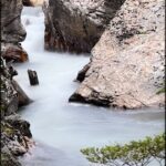 A river flows through a rocky canyon, creating a picturesque scene.