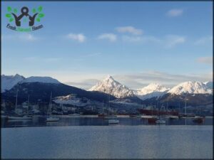 A serene lake with mountains in the background, surrounded by numerous boats.