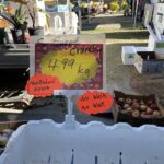 A sign advertising crunchy cinnamon apples is displayed at a market.