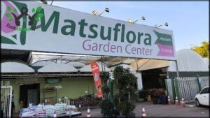 A sign for a garden center with a pink flower logo.