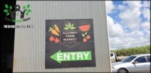 A sign for an Allway Farm Market is displayed on a building.