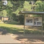 A sign in a park with a picture of a man and a woman on it.