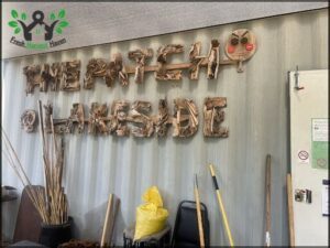 A sign that says "The Lake Side" is made of wood.