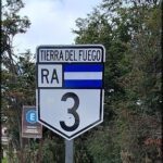 A sign with the number 3 on it is posted on a pole.