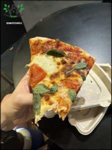 A slice of pizza with tomatoes and basil on a table.