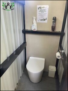 A small bathroom with a toilet and a shelf with toiletries.