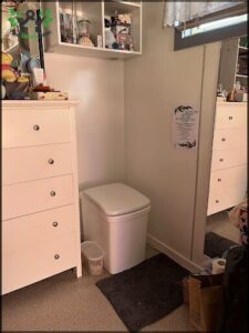 A small white toilet is placed in a corner of a room.