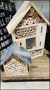 A small wooden bird house with a metal roof.