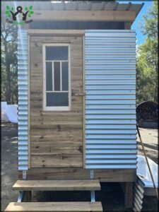A small wooden shed with a window and a door.