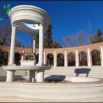 A statue of a cow is situated in the middle of a circular area, surrounded by pillars.