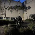A statue of people walking is located in front of a building.