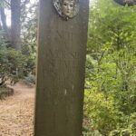 A stone monument with a carved face and the words "Not a mouse shall be disturbed in this Hallowed House."