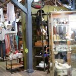 A store with a variety of items on display, including clothing, hats, and other accessories.