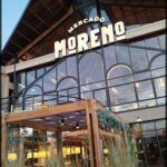 A storefront with a sign that reads "Mercado Moreno" and a large window.
