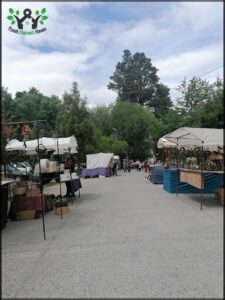 A street market with various items for sale, including a tent with a blue roof.