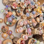 A table full of colorful glass beads and wooden sticks.