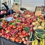 A table full of fresh fruits and vegetables, including tomatoes, peppers, and bananas.