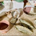 A table full of various bowls, cups, and vases.