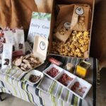 A table full of various food items, including a box of mushrooms, a bag of nuts, and a box of dairy cow hides.
