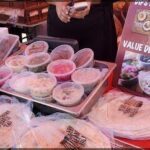 A table full of various foods, including a bowl of dip.