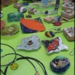A table full of various items, including a necklace, a pair of earrings, and a variety of beads.
