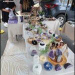 A table full of various items, including rocks, is set up for sale.