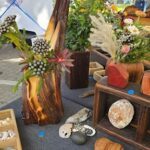 A table full of various plants and flowers, including a vase with a pineapple.