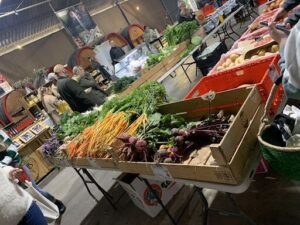 A table full of vegetables is displayed at a market.