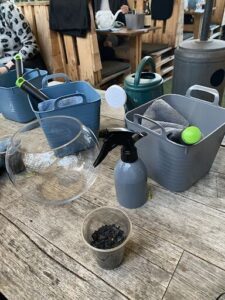 A table with a blue bucket, a green bucket, and a spray bottle.