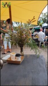 A table with a cup of coffee and a vase of flowers.