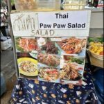 A table with a sign that says Thai Paw Paw Salad.