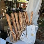 A table with a white tablecloth and a bag of bread on it.