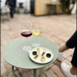 A table with two wine glasses and a plate of food.